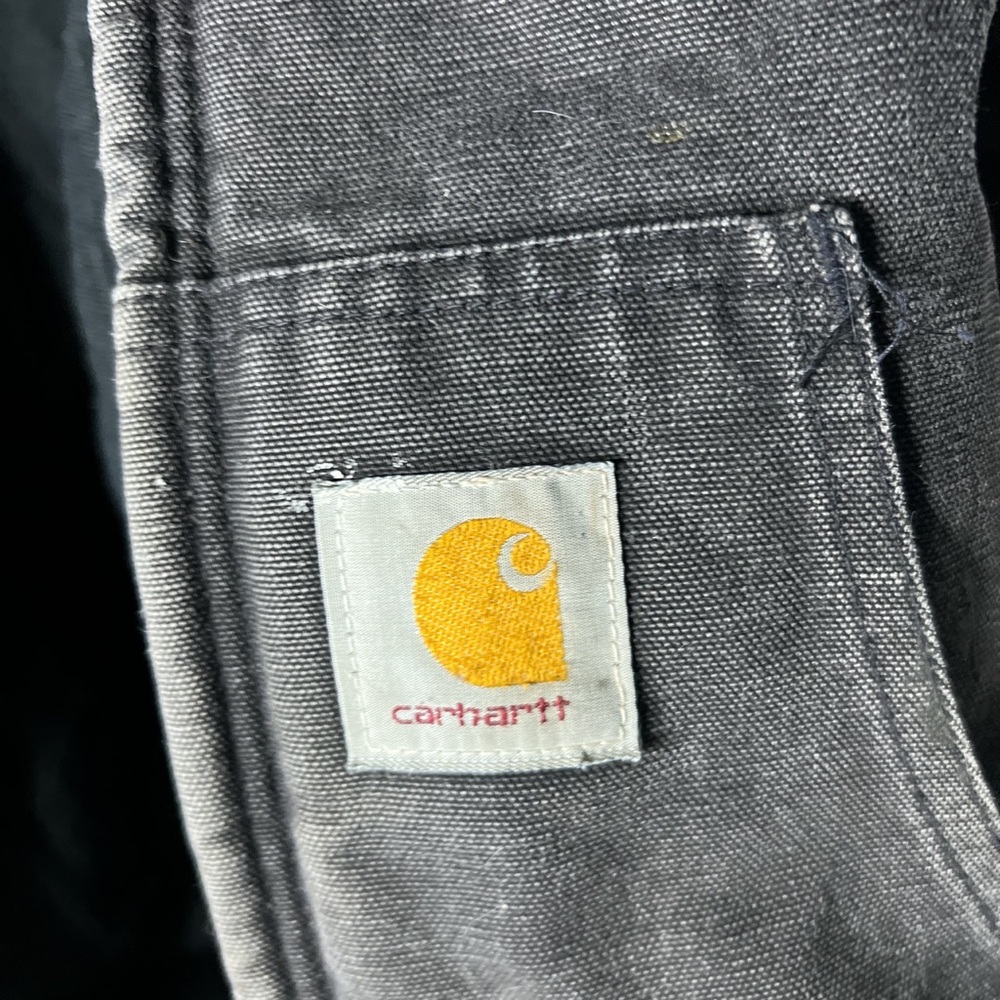 The original black of the jacket has faded.Has some white paint splatters.